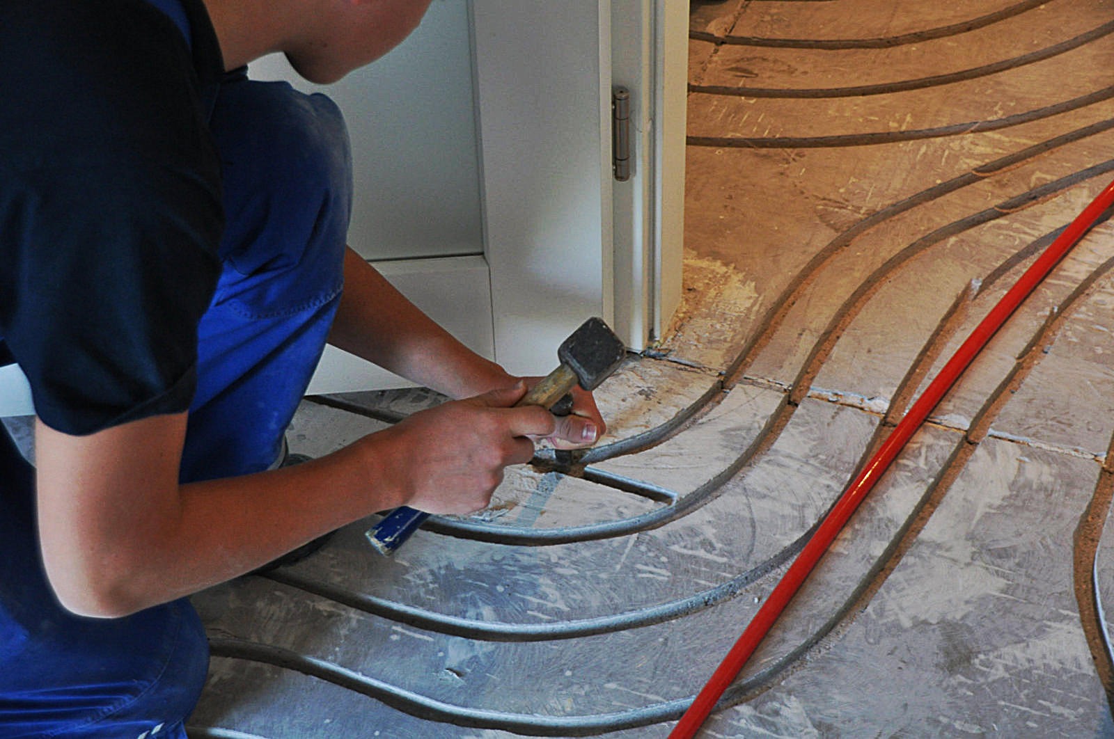 Drei Handwerker besprechen technische Details an einer installierten Wärmepumpe