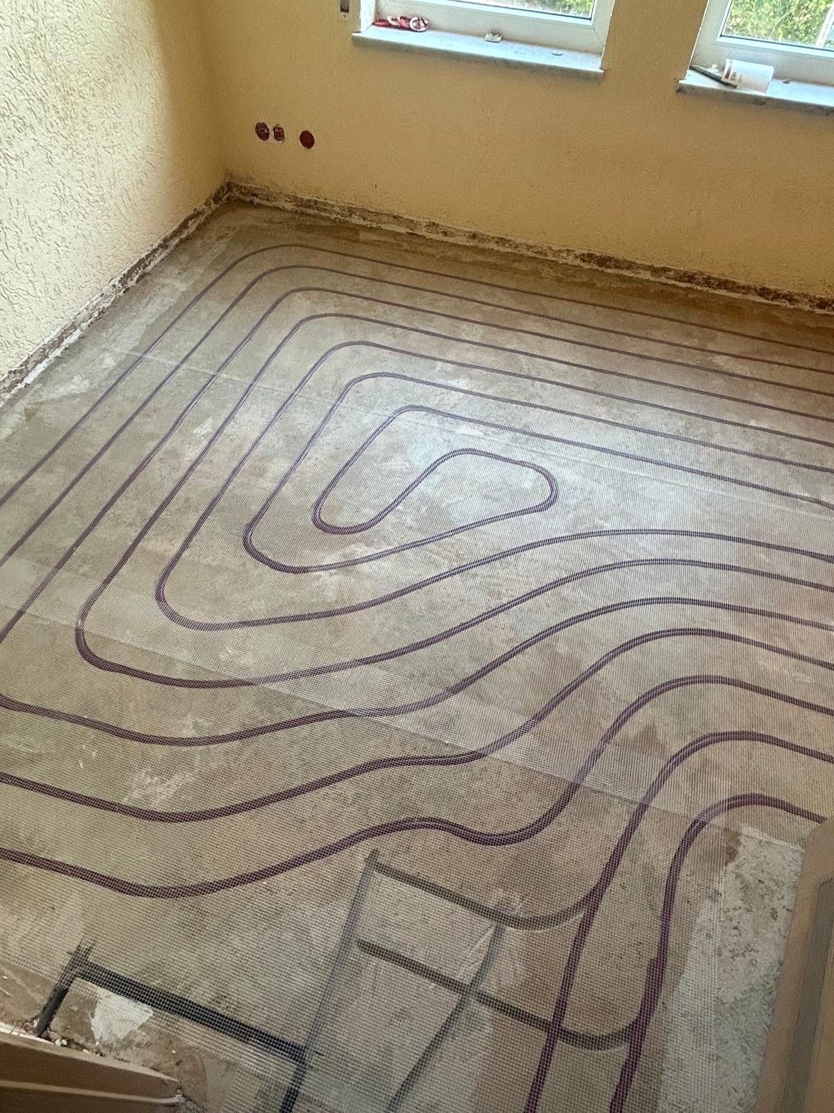 Lächelnder Handwerker demonstriert die Montage eines klappbaren Haltegriffs neben einer Toilette im barrierefreien Bad.